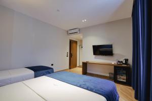 a hotel room with two beds and a flat screen tv at Duka's Hotel in Ksamil