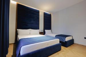 a bedroom with two beds with blue headboards at Duka's Hotel in Ksamil