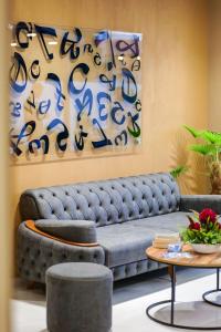 a living room with a blue couch and a painting at Duka's Hotel in Ksamil