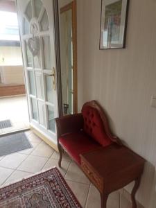 a living room with a red chair and a door at Ferienwohnung Gütl am Weg in Ebenzweier