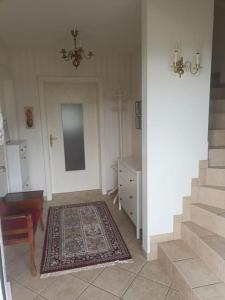 a living room with a staircase and a rug at Ferienwohnung Gütl am Weg in Ebenzweier