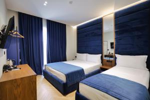 a hotel room with two beds and a desk at Duka's Hotel in Ksamil
