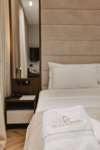 a hotel room with a white towel on a bed at Duka's Hotel in Ksamil