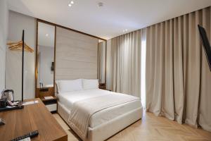 a bedroom with a bed and a desk with a computer at Duka's Hotel in Ksamil