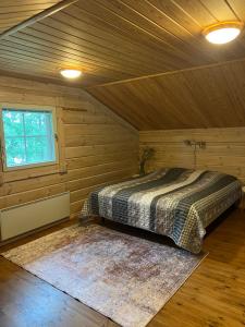 コリンカイラにあるHoliday Home Amero purnu 2の木造キャビン内のベッド1台が備わるベッドルーム1室を利用します。