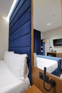two beds in a room with a mirror at Duka's Hotel in Ksamil