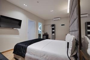 a bedroom with a bed and a flat screen tv at Duka's Hotel in Ksamil