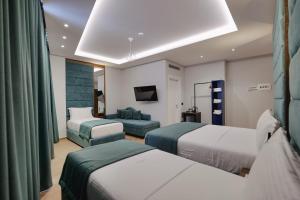 a hotel room with two beds and a couch at Duka's Hotel in Ksamil