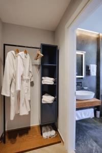 a bathroom with a sink and a shelf with towels at Duka's Hotel in Ksamil