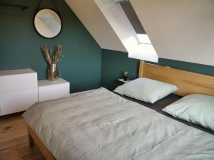 ein Schlafzimmer mit einem großen Bett und einem Spiegel in der Unterkunft Der Schuppen in Mildstedt