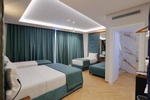 a hotel room with two beds and a window at Duka's Hotel in Ksamil