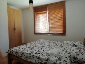 ein Schlafzimmer mit einem Bett mit einer Bettdecke und einem Fenster in der Unterkunft Villa Harmony in Bihać