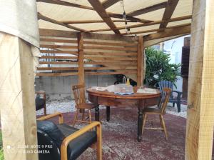 Villa Sofia-La camera nella Riserva في Pettorano sul Gizio: بروجولا خشبي تحته طاولة وكراسي