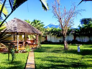 a resort with a grass hut with palm trees at Heart Of Africa Adventure and Apartments in Arusha