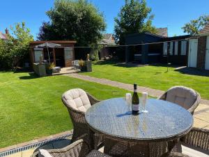a table and chairs with a bottle of wine on it at BeRo Bungalow with a hot tub & a large garden! in Withernsea