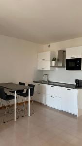 a kitchen with white cabinets and a table and chairs at Casa Valentina 2 in Perugia