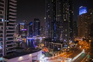 een skyline van de stad 's nachts met veel hoge gebouwen bij Lunar Hostel in Dubai