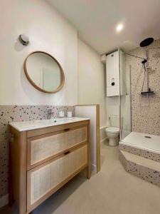 a bathroom with a sink and a toilet and a mirror at La wim’ au bord de l’eau in Wimereux