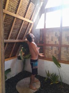Un niño mirando por una ventana en un edificio en Apache surf villa en San Isidro