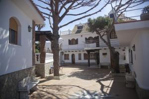 a building with a tree in the middle of a courtyard at Hostal Mar de Frente in Los Caños de Meca