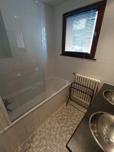 y baño con bañera, lavamanos y ducha. en Superbe appart 6p Tignes Le LAC en Tignes