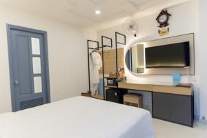 1 dormitorio con 1 cama y escritorio con TV en A25 Hotel - 14 Lương Hữu Khánh, en Ho Chi Minh