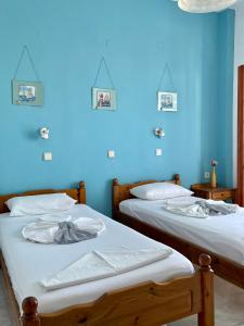 two beds in a room with blue walls at Panorama Rooms in Agia Roumeli