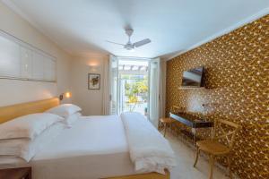 1 dormitorio con 1 cama blanca grande y escritorio en Cape Standard Guest House en Ciudad del Cabo