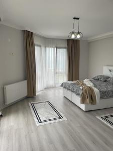 biała sypialnia z łóżkiem i dużym oknem w obiekcie Parlayan Suite Trabzon w mieście Akcaabat