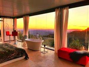 a bedroom with a bath tub and a large window at DDG Retreat in Casares