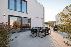 patio con tavolo e sedie sopra di Villa Fortunal a Murter