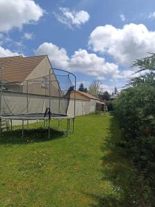 ein Trampolin in einem Hof neben einem Haus in der Unterkunft Évasion familiale à Plaisir in Plaisir