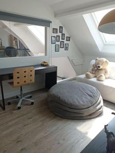 a teddy bear sitting on a bed in a bedroom at Évasion familiale à Plaisir in Plaisir