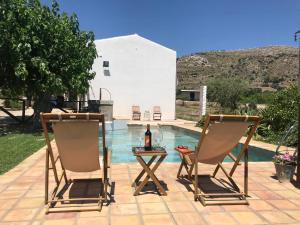 dwa krzesła i stół obok basenu w obiekcie Authentic Sicilian Charm, pool, sea view, wi-fi & parking w mieście Avola