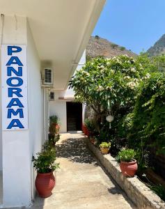 a building with potted plants and a sign on it at Panorama Rooms in Agia Roumeli