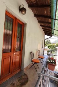 eine Eingangstür eines Hauses mit zwei Stühlen in der Unterkunft Appartamento Le Cascate 1° Piano in Cittiglio