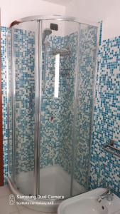 ein Bad mit einer Dusche und blauen Fliesen in der Unterkunft Appartamento Le Cascate 1° Piano in Cittiglio