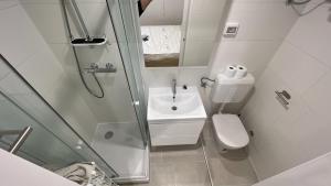 uma casa de banho com um chuveiro, um WC e um lavatório. em 2023 Bruno - wifi and parking available em Portorož