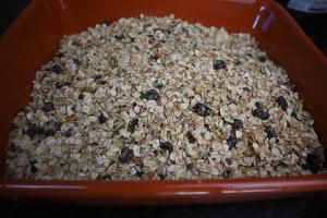 a red bowl filled with granola on a table at Quinta Ecológica da Peneda Agroturismo by Peneda ecofarm in Arcos de Valdevez