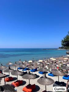 a beach filled with lots of umbrellas and the ocean at Mabel Rooms in Durrës
