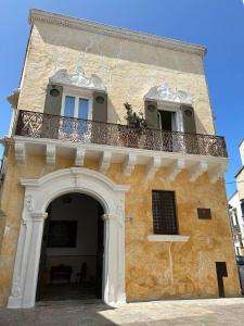 un bâtiment avec un balcon au-dessus dans l'établissement Pascaraymondo Suite Palace, à Gallipoli