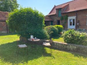 a table and chairs in the yard of a house at Le chat sur le balai in Ecques