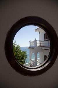 a view of a building through a circular window at Hostal Mar de Frente in Los Caños de Meca