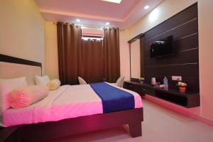 a bedroom with a bed with a television and a bedskirtspectspects at SHAKTI VILLA HOME STAY in Agra