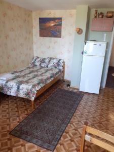 a small room with a bed and a refrigerator at Апартамент Вангелов in Nesebar