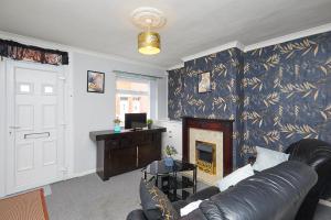 a living room with a couch and a fireplace at Comfortable 4-Bed House in Hucknall Nottingham in Nottingham