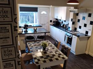 una cocina con una mesa con una barra de tablero de ajedrez en Comfortable 4-Bed House in Hucknall Nottingham, en Nottingham