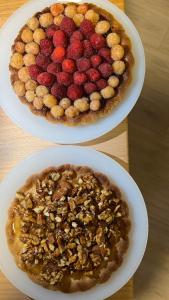 two plates of food with a pie with fruit on it at B&B22 in Santa Brigida