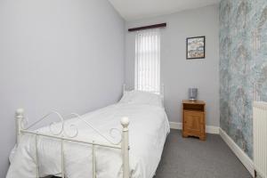 a bedroom with a white bed and a window at Comfortable 4-Bed House in Hucknall Nottingham in Nottingham