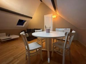 - un salon avec une table et des chaises blanches dans l'établissement Appartement des Vignes, à Metz